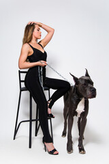 Beautiful slender model dressed in the black suit with dog
