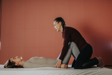 Obraz premium A wellness expert provides a therapeutic stretch to a person, promoting relaxation and well-being. The setting features a serene ambiance with care and focus on health and physical improvement.