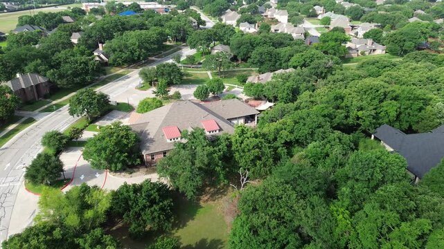 Briarhill Boulevard in Highland Village row of upscale two-story suburban houses nested in lush greenery mature landscaping residential neighborhood school district in Dallas Fort Worth metroplex