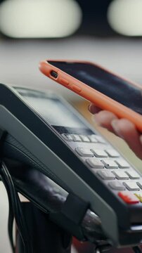 Close-up of woman fem ale customer hand putting smartphone touching terminal payment scanning nfc technology contactless payment wireless device concept. Supermarket.