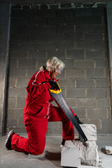 A woman works with bricks at a construction site.