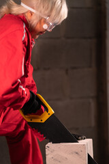 Side view of a woman cutting bricks.