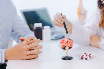 Female doctor gives advice and explanation to patient with dementia and stroke in examination room...