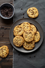 Rustic chocolate chip cookies, on metal plate. Dark wood background.
