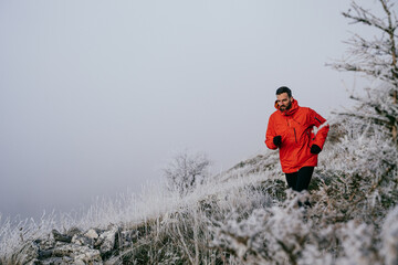 Man Climbing Rocky Hill in Fog