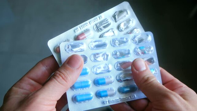 Hands holding empty pill packages, symbolizing medication dependency and fading hope. Failed treatment cycle shown through capsules and exhausted pharmaceutical solutions. Therapy ineffective concept
