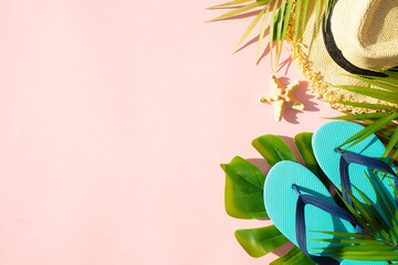 Summer cloth and accessories with palm leaves on pink background. Flat lay with space for design.