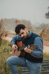Man Practices Arpeggios on Guitar While Playing Outdoors