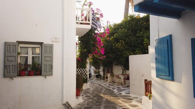 Myconos typical white street leading to sea with sunshine, small village on Paros island, Greece