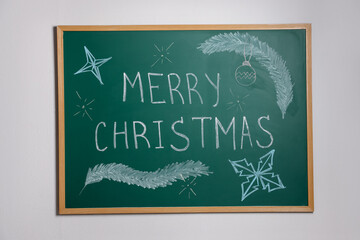 Phrase Merry Christmas and different drawings on green chalkboard