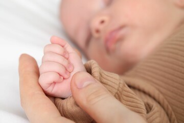 Mother with her little baby on bed indoors, closeup