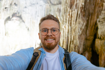 Travel selfie Young caucasian male exploring cave in Halong bay, Vietnam