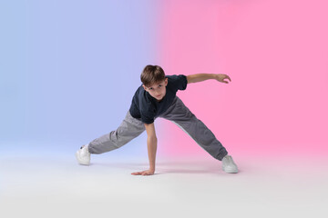 Boy in stylish clothes dancing on color background