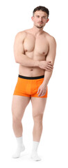 Young man in stylish orange underwear on white background
