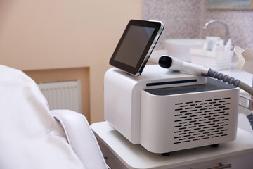 Naklejka premium Laser hair removal machine and medical couch in beauty salon