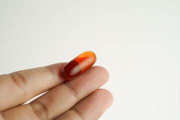 Male hand holding Oil filled capsules, softgel of food supplements, fish oil, omega 3, vitamin E