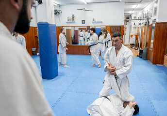 Karate instructor showing martial arts technique to students in dojo