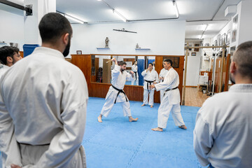 Karate athletes practicing knife fighting techniques during training in the dojo