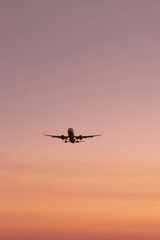 solitary airplane soaring through sky at sunset bathed in soft warm light