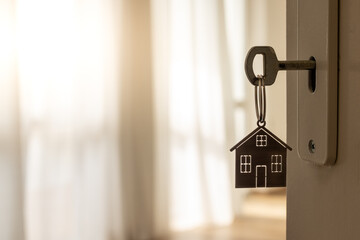 Open door to a new home with key and home shaped keychain. Mortgage, investment, real estate, property and new home concept
