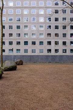 Modern building facade with repetitive square windows and central courtyard, ideal for copy space, architectural texture, and urban design themes in stock.