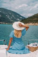 Woman with blonde hair sitting on boat in Southern France