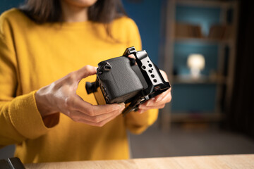 Close-up of photographer hands mounting metal cage on camera body