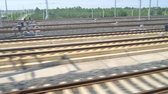 POV shot of multiple parallel railway tracks rushing past, suggesting high-speed travel, logistics, and infrastructure.


