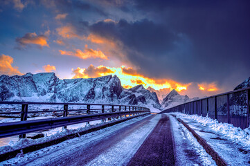Icy road at Hamnoy bridge covering with snow on the way to go to Hamnoy fisherman village popular tourist attraction in Lofoten, Norway