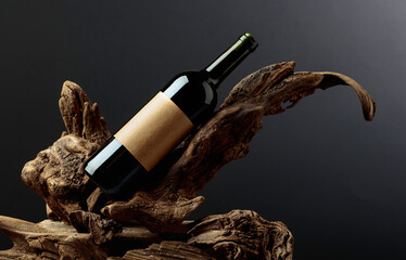 Bottle of red wine with empty label on a old snags.