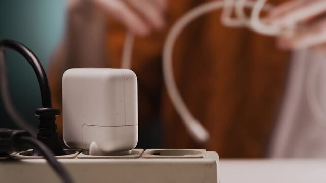 Closeup of a mans hand take-on a type-c wire from electrical power strip.
