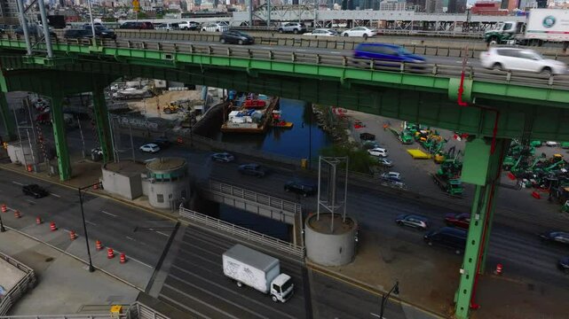 Dynamic drone footage of the Brooklyn-Queens Expressway (BQE) adjacent to the Park Slope neighborhood in Brooklyn, New York. Captured in May daylight, the video contrasts heavy traffic and layered inf