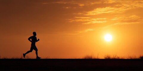 Silhouette of a man jogging at sunset. Warm colors and peaceful mood.