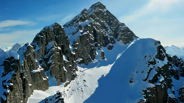 Sharp snow ridge slices across jagged massif, blue shadows stretch as skiers carve trails beyond snow ridge cornices and cold wind guards untamed snow ridge heights. concept winter exploration