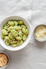 Portion of potato gnocchi with basil ‘Pesto’ sauce, on light gray background. Italian food.