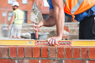 Bricklayer laying bricks on building site