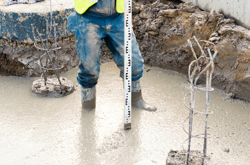 Construction worker using laser level to check level on construction site