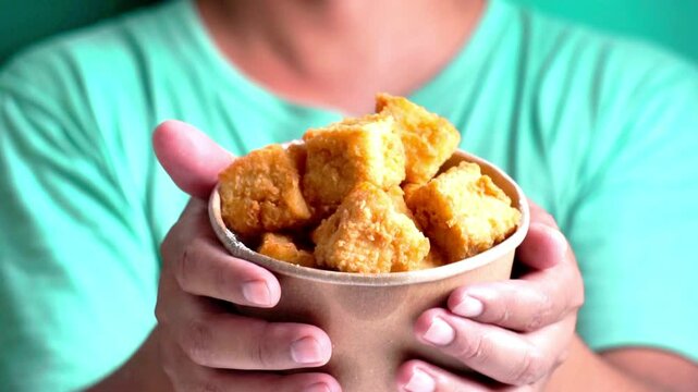 Crispy tofu (tahu crispy) in a paper bowl. Indonesian street food.