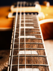 Vintage rock guitar on a dark background, selective focus on the fretboard