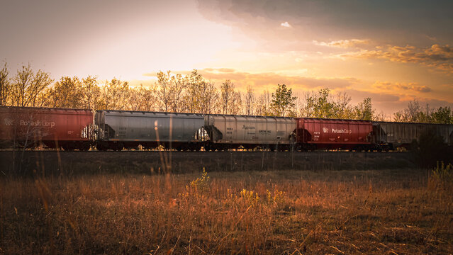 A train at sunset transporting agriculture commodities through the Minnesota prairie in May 2025. Agrium merged with PotashCorp to form the new company, Nutrien in 2018. Editorial Use Only.