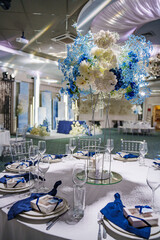 table setting with blue flowers and napkins.