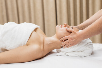Young woman during a facial massage in a spa. The concept of relaxation, spa and cosmetology.