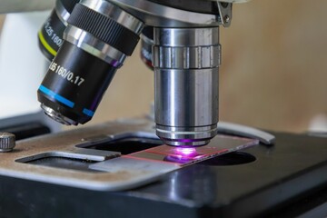 Microscope close-up with glowing slide.