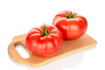 Two pink tomatoes on a wooden kitchen board, close-up, isolated on a white background.