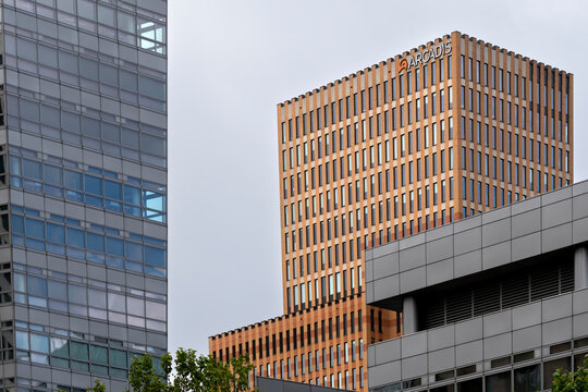 Contemporary office buildings with warm terracotta facades and glass structures under clear sky, ideal for commercial architecture and urban planning concepts in stock.
