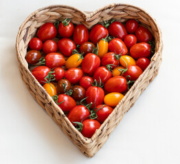 Herzvolle Frische. Bunt gemischte frische und knackige Tomaten im Herz Korb.