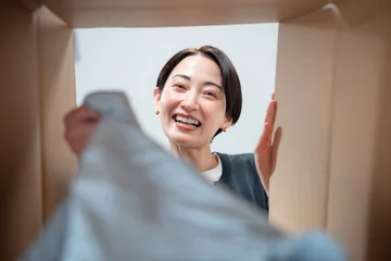  ダンボールを覗く女性 © naka