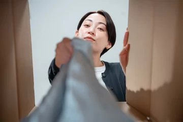  ダンボールを覗く女性 © naka
