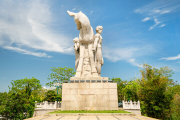Fototapeta premium China Hainan island, Sanya city symbol, girl and the deer turning his head