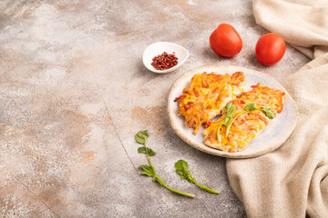 baked chicken meat with cheese and tomatoes on brown concrete. side view, copy space